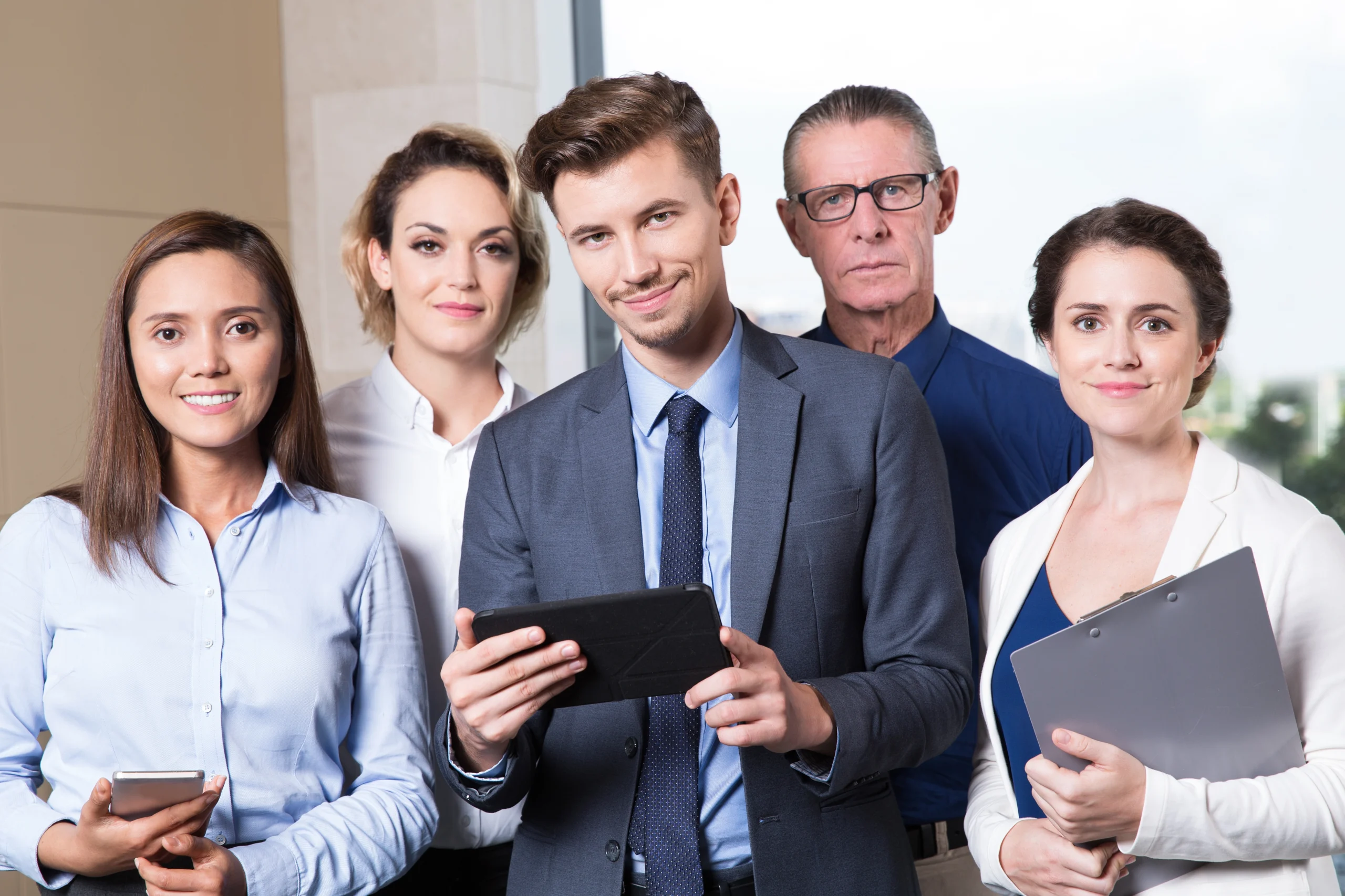 diverse business team members posing in a modern office setting.