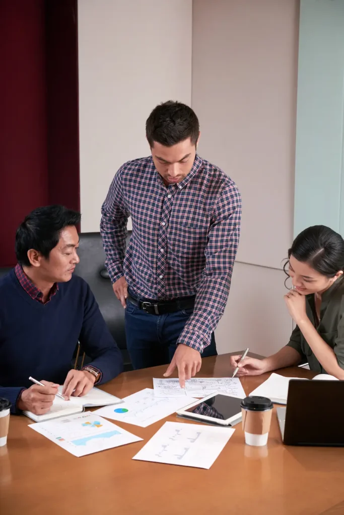 Business colleagues collaborate around a conference table in a modern office.